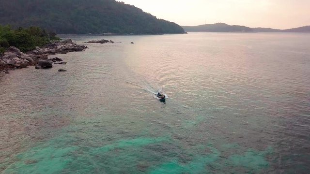 Sunrise aerial view of a boat on crystal clear waters at Perhentian Islands (Pulau Perhentian)