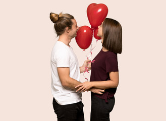 Couple in valentine day with balloons with heart shape over isolated background