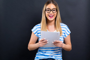 Young woman with notebook and pencil on a black background