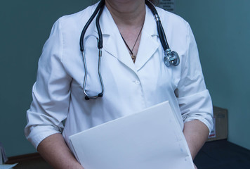 Doctor in white coat with a stethoscope and a folder of medical history in the hands