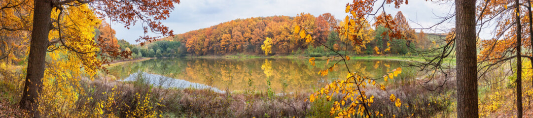 Autumn landscape - the forest by lake in the sunny autumn day, panorama, banner