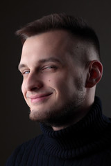 Obraz premium Young man close up portrait, on black background.Emotion. Smile.Shy