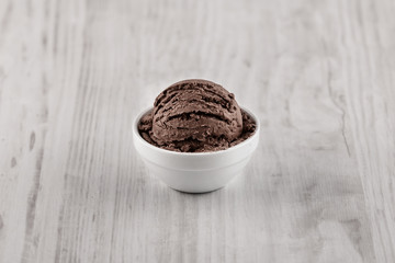 Chocolate ice cream with bowl on wooden background