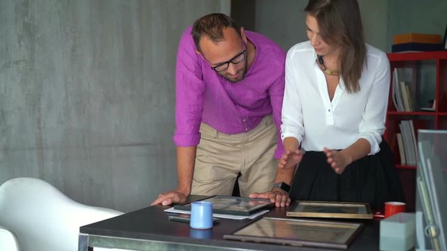 Businessman and businesswoman talking over project at home office