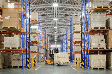 Forklift truck in warehouse or storage and shelves with cardboard boxes. - obrazy, fototapety, plakaty