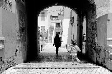A little girl run towards her mom in the picturesque Italian village. San Felice Circeo, Lazio, Italy