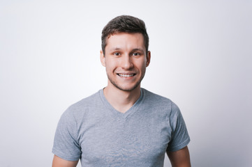 Portrait of smiling young man in gay tshirt, looking at camera over white background