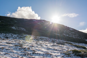 Sun beams over snow dappled mountain summit in Gros Morne National Park Newfoundland, Canada