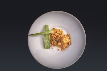 Aloe vera and turmeric with medicinal values in white plate and black background