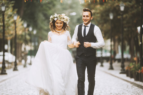 A loving couple of newlyweds walks in the city. Husband and wife happy smiling on a walk