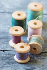 Fototapeta na wymiar Sewing kit. Spools of thread on old wooden table.