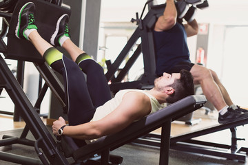 Man training leg in press exercise with ambien light