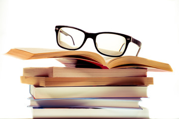 Bücherstapel zum Studieren mit einer schwarzen Brille darauf