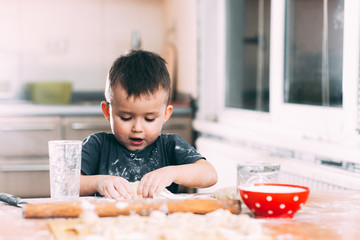The child makes dough dumplings or dumplings is fun with enthusiasm