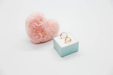 Pink heart with a rings in gift box on the white background