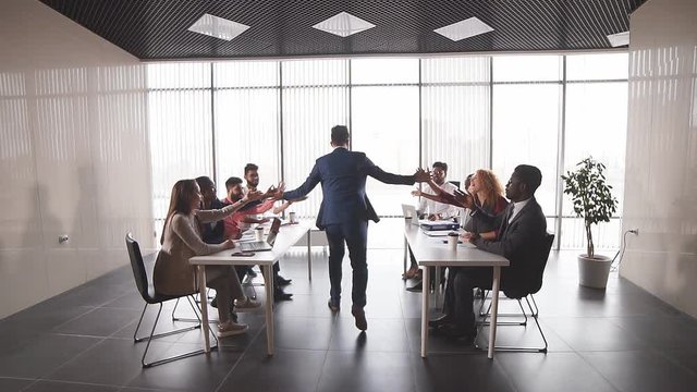 happy office workers rejoicing at good results of their company. best leader. promotion, successful boss is getting congratulations fron co-workers