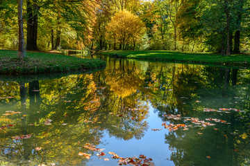 Obraz premium Autumn trees over a pond in a park