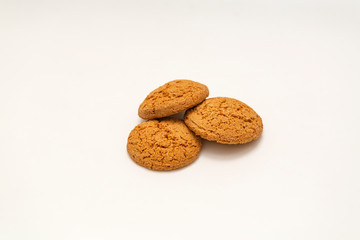 Fototapeta na wymiar Three homemade oatmeal cookies isolated on white background. Closeup