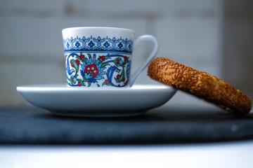 close up cup of Turkish coffee in traditional ottoman ornament cup with traditional Turkish delight - simit