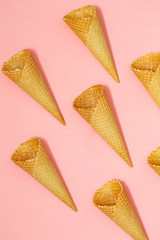 Ice cream waffle cones on pastel pink background, top view flat lay, minimal composition. Place for text