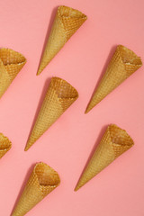 Ice cream waffle cones on pastel pink background, top view flat lay, minimal composition. Place for text