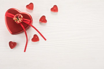 Valentine day composition: red gift box and heart shaped candles - Powered by Adobe