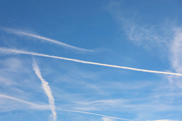 Fototapeta na wymiar many contrails left by airliners or are white chemtrails accordi