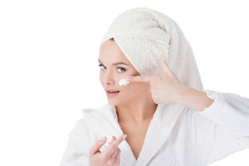 To use the cream after a shower. Portrait of a young attractive woman in a Bathrobe and a towel on her head.