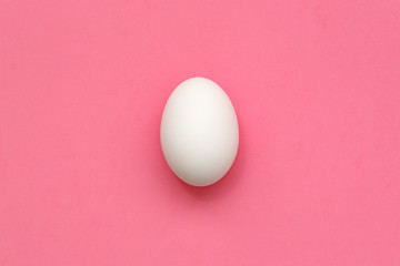 White Easter egg on pastel background. Happy Easter concept. Minimal concept. Flat lay. Top view.
