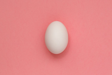 White Easter egg on pastel background. Happy Easter concept. Minimal concept. Flat lay. Top view.