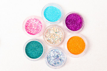 small colorful jars of glitter and sequins for body tattoo close-up