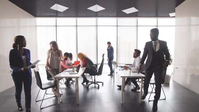 Young successful business people giving advice and correcting mistakes during the meeting. Cooperation