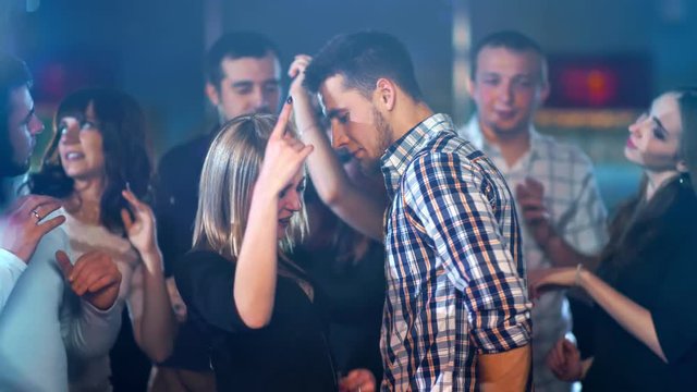 Young happy couple is dancing at a party