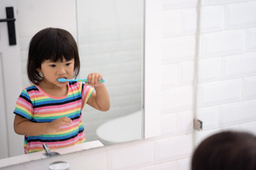 Fototapeta na wymiar toddler independently brush her own teeth