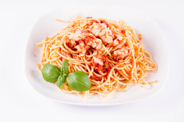 Spaghetti bolognese with melted parmesan cheese decorated with basil on a white background