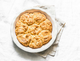 Cottage cheese whole-grain rolls in a baking dish on a light background, top view