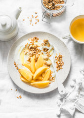 Caramelized quince with Greek yogurt, granola and nuts on a light background, top view. Delicious healthy breakfast, brunch, snack