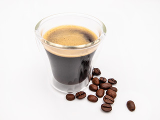 Glas of arabica espresso coffee with a few roasted coffee beans isolated on a white background