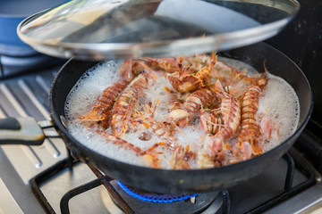 boiling a pot of mantis shrimps in the kitchen with the lid up