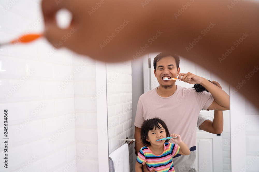 Wall mural father and daughter brushing teeth together