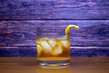 Old Fashioned cocktail with ice and lemon rind
