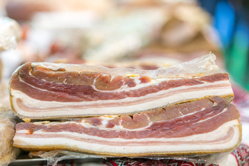 Obraz premium Two pieces of smoked pork. Delicious artisanal whole smoked slab bacon on a cutting block. Pork belly Farm fresh Pork