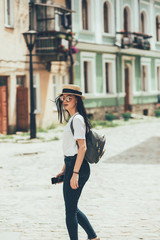 Pretty brunette woman internet blogger talking by smartphone in old city