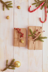 Christmas gift boxes and fir tree branch on wooden table, flat lay. Сhristmas background