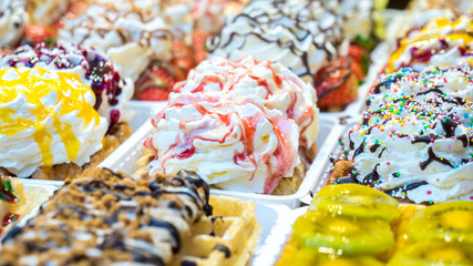 colorful cake sweet dessert with whipped cream at a street food market