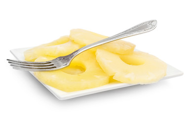 Plate with canned pineapple rings and fork on white.