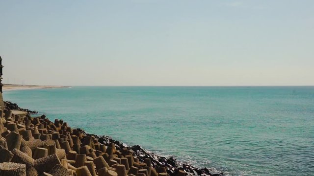 Panning shot of breakwater, lighthouse, temples near dwarka beach Gujarat india