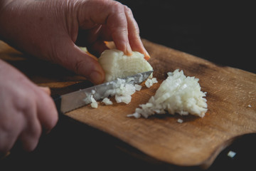 cutting white onion with knife 