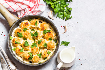 Meatballs in cream sauce with parmesan cheese top view.