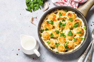 Meatballs in cream sauce with parmesan cheese top view.